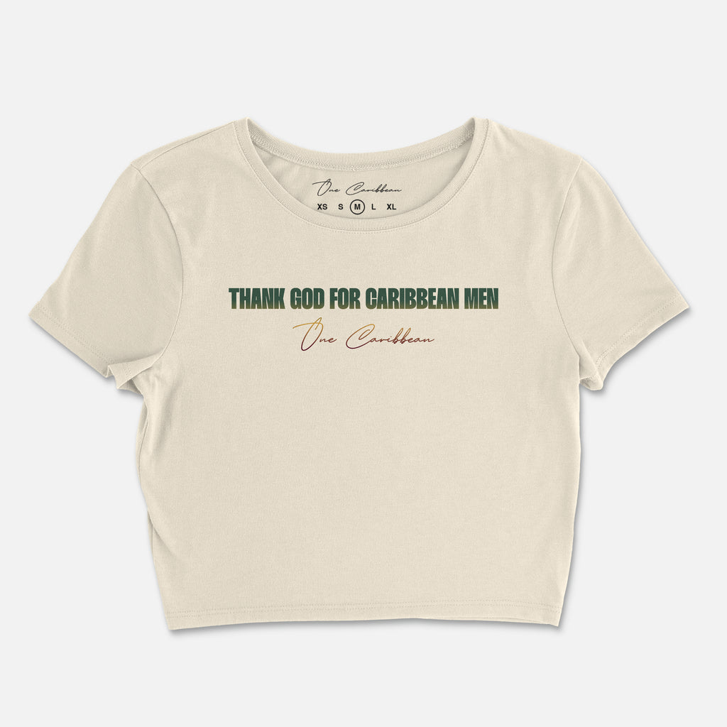 An ivory crop top with the text 'THANK GOD FOR CARIBBEAN MEN' printed in gradient colors on the back.